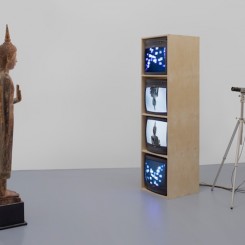 Nam June Paik, "Standing Buddha with Outstretched Hand," single-channel video (color, silent) with televisions, closed-circuit video (color), and wood Buddha with permanent oil marker additions, dimensions variable, 2005. © Nam June Paik Estate. Courtesy Gagosian Gallery.