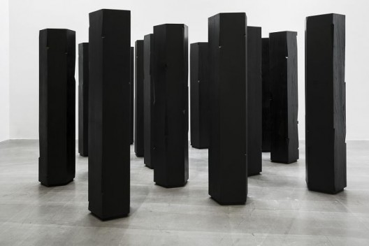 杨牧石，《切入-柱》，榆木实木板，黑色喷漆，17件，每件高173 cm，直径50 cm，2015