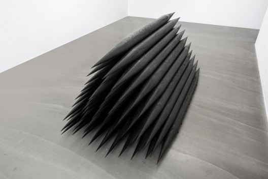 杨牧石，《刨除-栋梁》，房梁木，黑色喷漆，55件，每件长200 cm，直径9 cm，2015