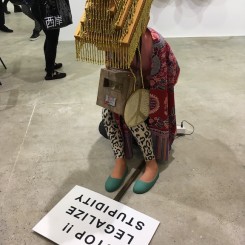 Squatting figure, art fair