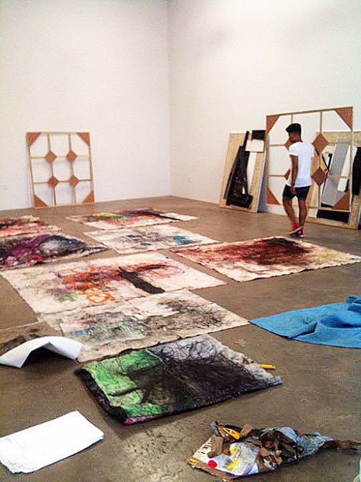 Oscar Murillo installing works at Nicodim Gallery, 2011 (courtesy of the artist and Nicodim Gallery)