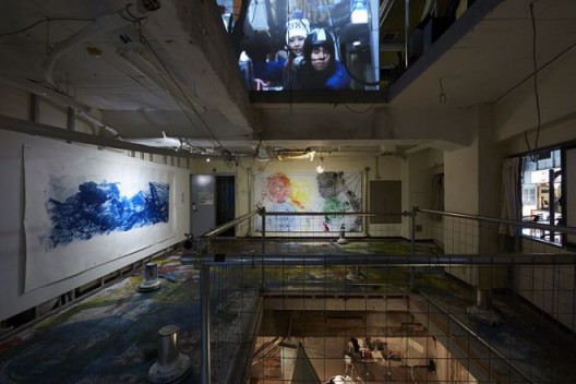 Chim↑Pom，《人们造了一座城》（左）、《五环》（中）和《都市悖论》（地板装置），2016（版权：Chim↑Pom；鸣谢：艺术家和东京MUJIN­TO Production）/ Chim↑Pom, “The People Make the City” (left), “Five Rings” (center), and “Downtown Paradox” (floor installation), 2016 (© Chim↑Pom; courtesy of the artist and MUJIN­TO Production, Tokyo)