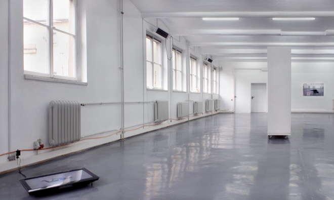 Installation view: Monitor, HD video, sound, 6:54 min.: Featuring dancer / actor Búi Rouch Hollow wooden wall on wheels (315 x 210 x 50 cm) Laser print on paper (84,1 x 118,9 cm) (documentation of performance) Club-Mate bottles and various other kinds of bottles Hand blown glass (various dimensions)
