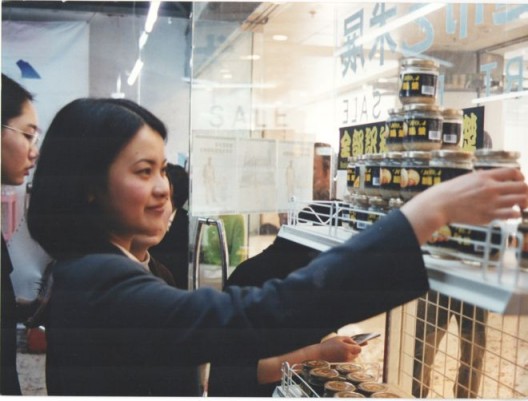 1999年4月10日“超市”展的第一天，一位观众正在拿起朱昱作品《全部知识学的基础》——一瓶死人脑汁做成的浆糊 April 10th, 1999, a viewer looks at the first part of Zhu Yu's 