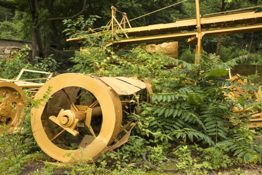 《金光采矿区》局部。艺术家将这些遍布铜锈的庞大机械全部喷成金色，成为郑国谷近年颇多讨论的能量学试验场。/ Part of the “Golden Mining Field”. The artist painted these huge rusted machines in gold—a site of experimentation for Zheng Guogu’s research on energy fields.